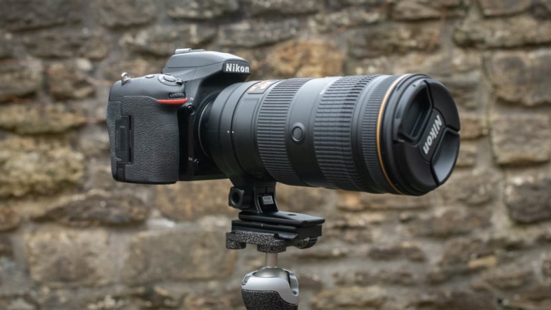 Camera and telephoto lens attached to tripod via tripod collar