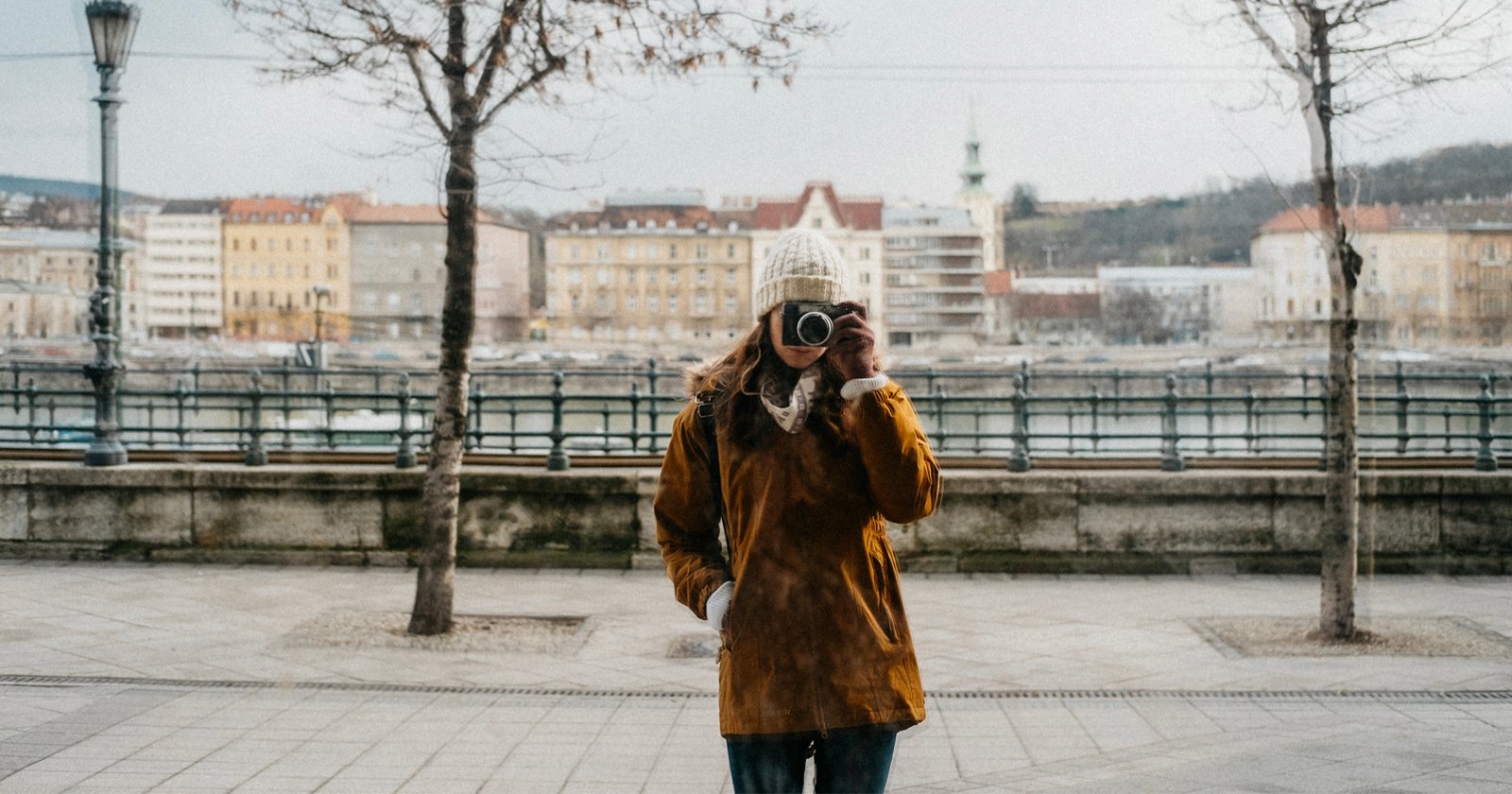 A photographer's reflection in a window on the street in Budapest