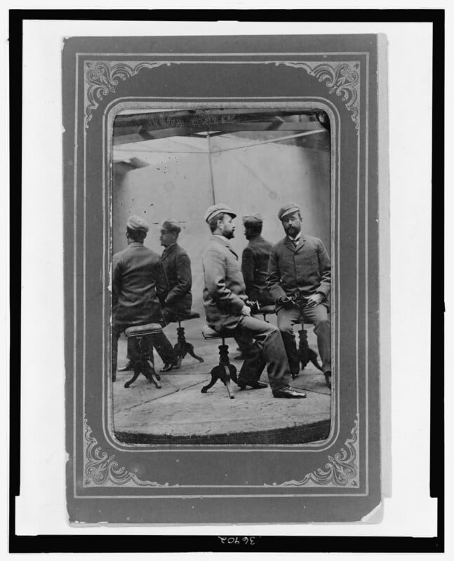 A man sits in a studio with two mirrors, creating five versions of himself.